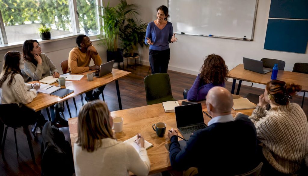 De docent geeft in de klas een uitleg over blended learning en laat zien hoe deze mix van online en offline onderwijs werkt.