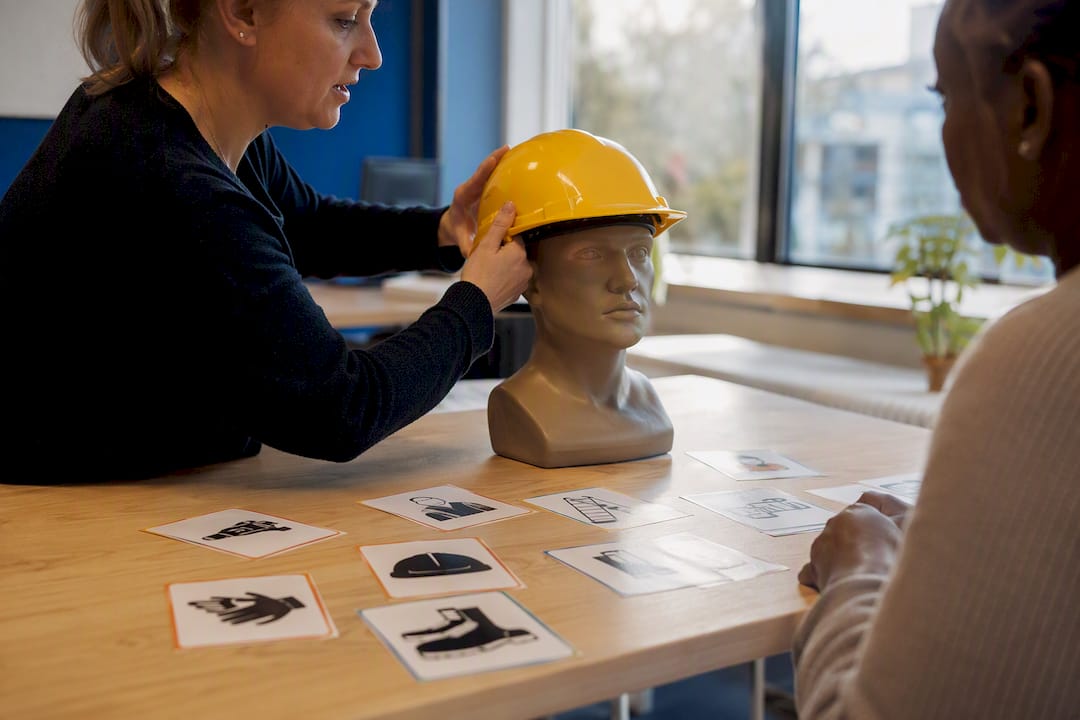 Handen die een veiligheidshelm opzetten tijdens een training