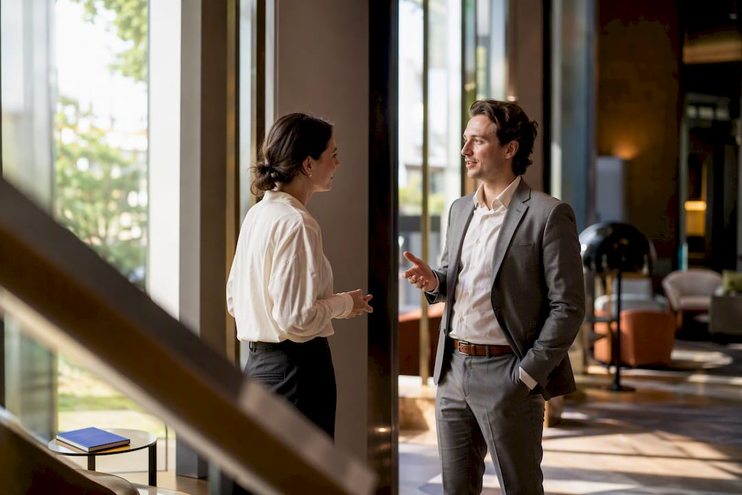 Twee professionals voeren een ontspannen gesprek in het Engels